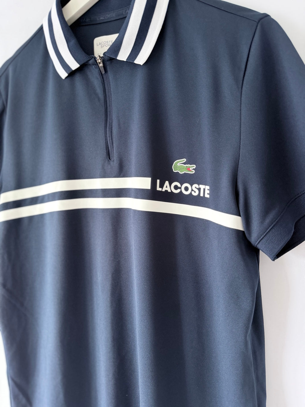 Lacoste Sport navy quarter zip polo shirt angled view